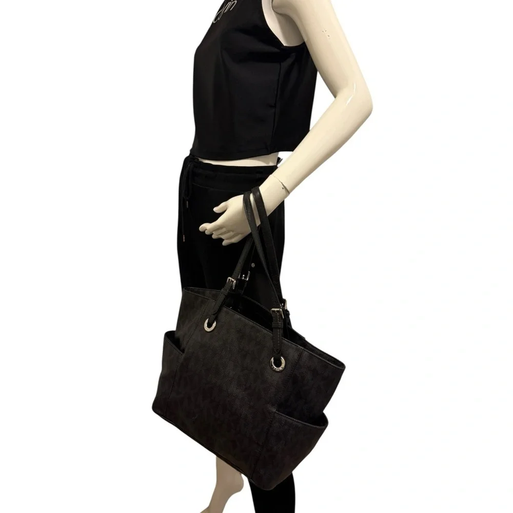 Michael Kors Elegant Black Handbag. Sides packets with a log in the front